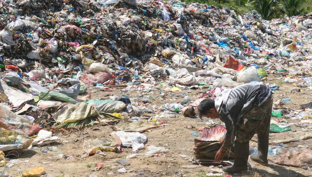 A scavenger collects reusable plastic from the illegal open dumpsite in Malapatan town in the southern Philippines. Image by Bong S. Sarmiento.