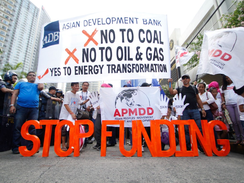 Police officers block climate activists protesting in front of the headquarters of Asian Development Bank during the annual meeting of the board of governors on May 4, 2018. They are calling to stop funding dirty energy sources and start supporting renewable energy in Asia. Image by AC Dimatactac/350 Pilipinas